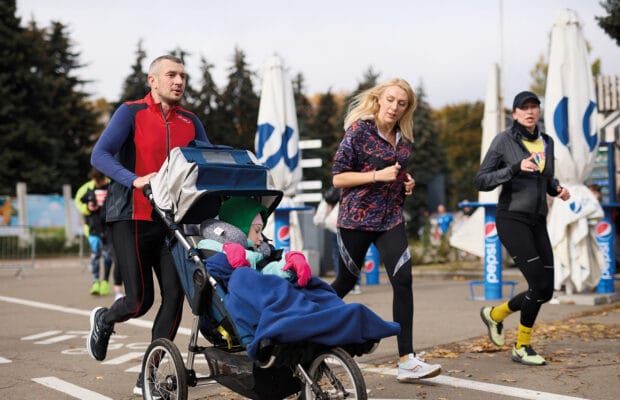 Une famille court un marathon avec une poussette